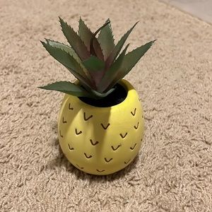 Fake plant in pineapple vase